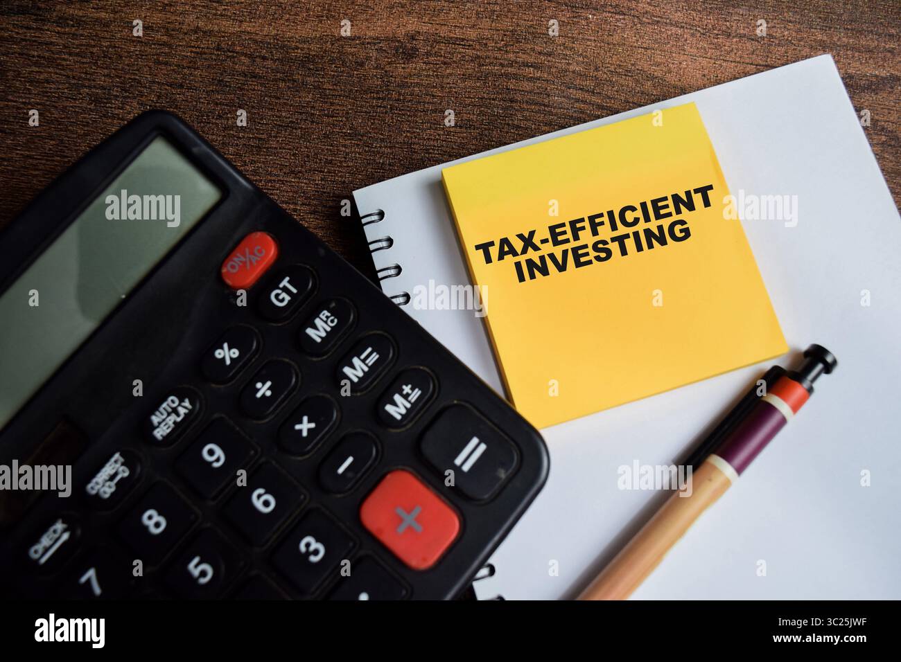 Concetto di investimento efficiente sotto il profilo fiscale scrivete su note adesive isolate su un tavolo di legno. Foto Stock