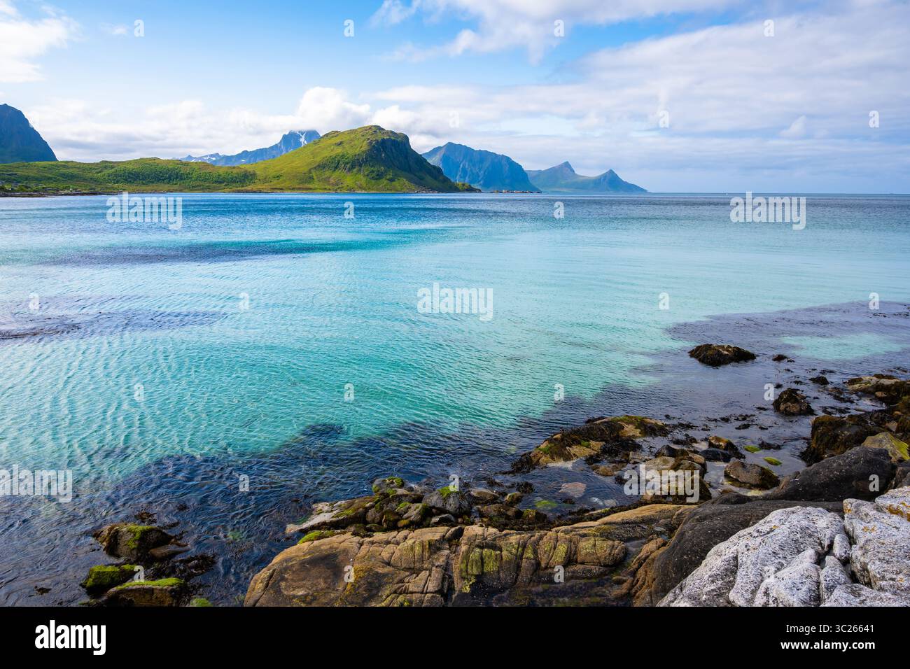 Acque cristalline sulla spiaggia di Vik e vista delle montagne in estate, delle isole Lofoten, Norvegia Foto Stock