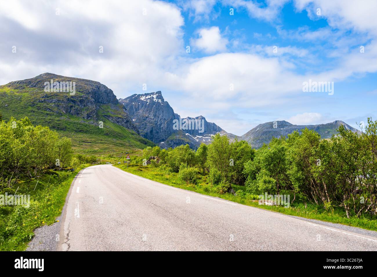 Strada per il villaggio di Nusfjord e il paesaggio montano sull'isola di Flakstadoya in estate, isole Lofoten, Norvegia Foto Stock