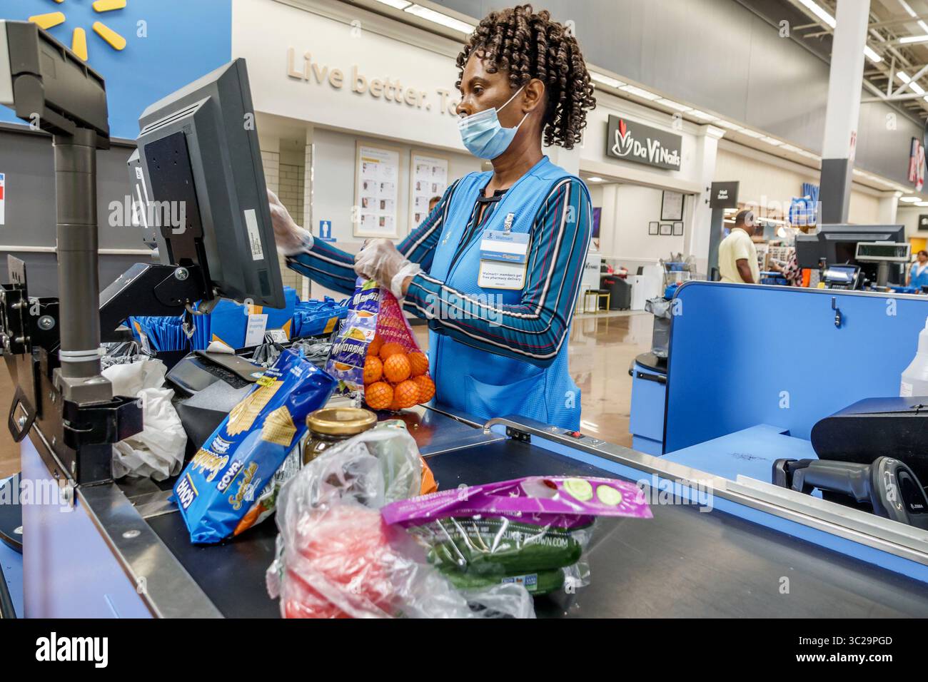 North Miami Beach, Florida, grande scatola per grandi magazzini Walmart, interni interni, scaffali in vendita, dipendente di colore donna che indossa il mas Foto Stock