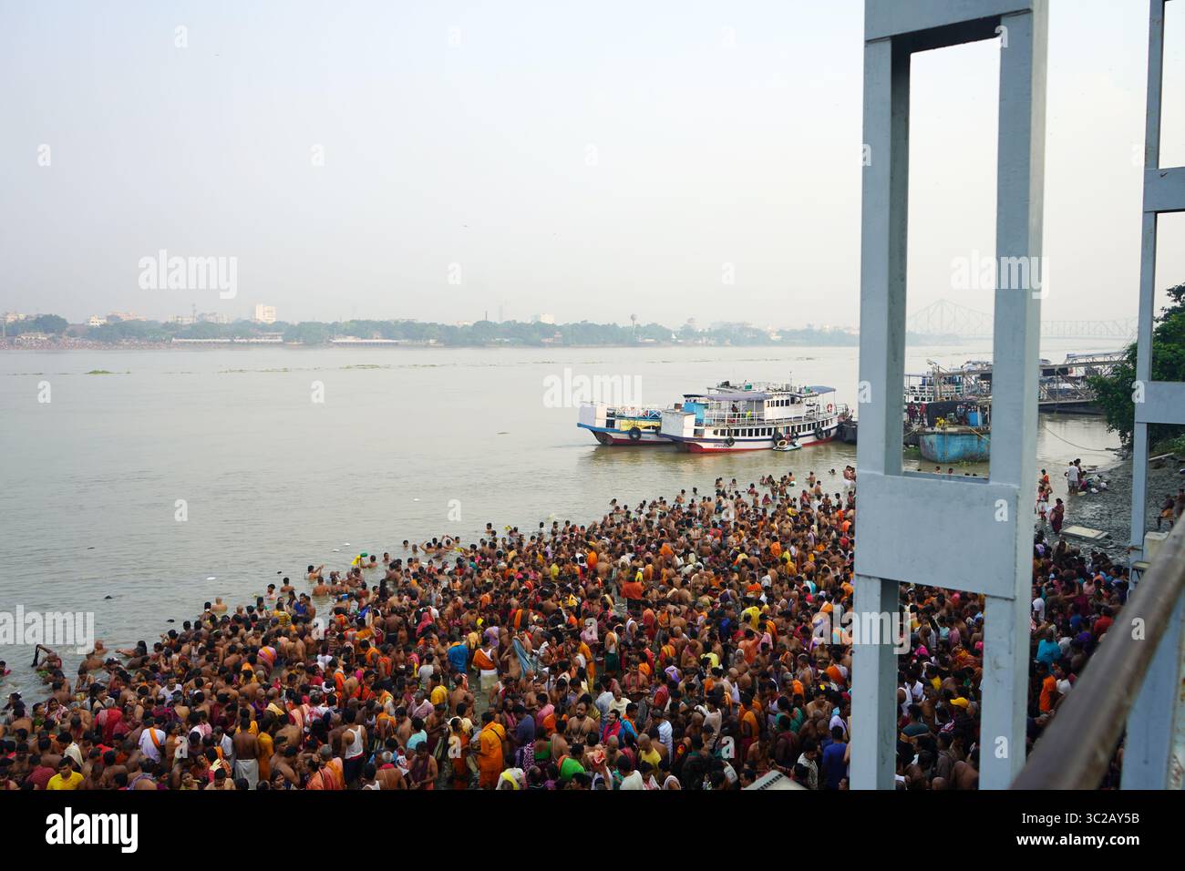 14 ottobre 2023, Babughat, Kolkata, Bengala Occidentale, India. Rituale di massa Tarpan che fa il bagno sul Gange all'alba vicino al ponte Howrah Foto Stock