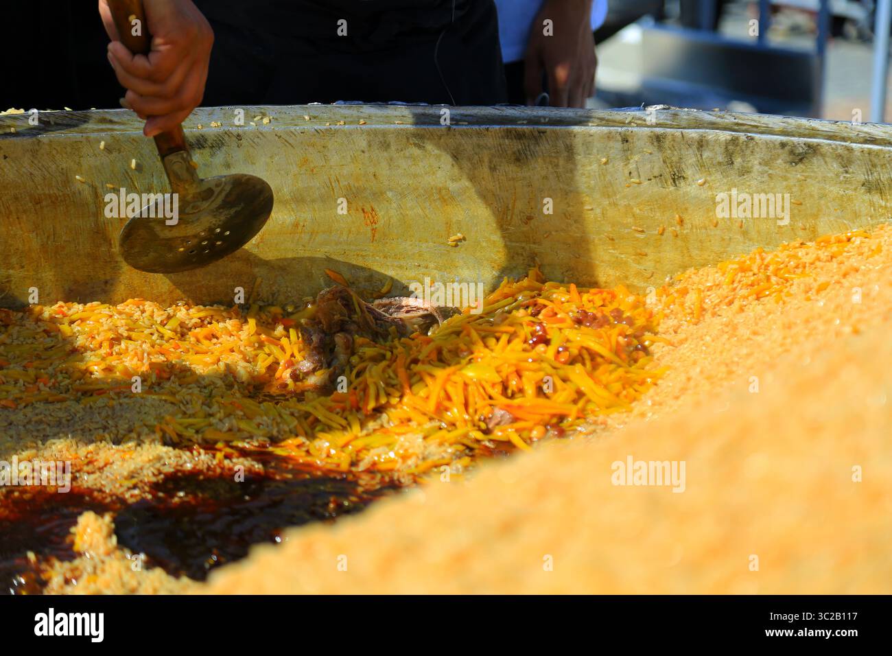 Secondo la ricetta di Samarkand Plov, gli ingredienti saranno cotti a strati. Foto Stock
