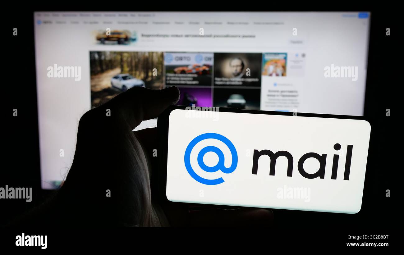 Stoccarda, Germania - 05-27-2025: Persona che detiene un telefono cellulare con il logo della società tecnologica russa Mail.ru sullo schermo di fronte alla pagina web. Foto Stock