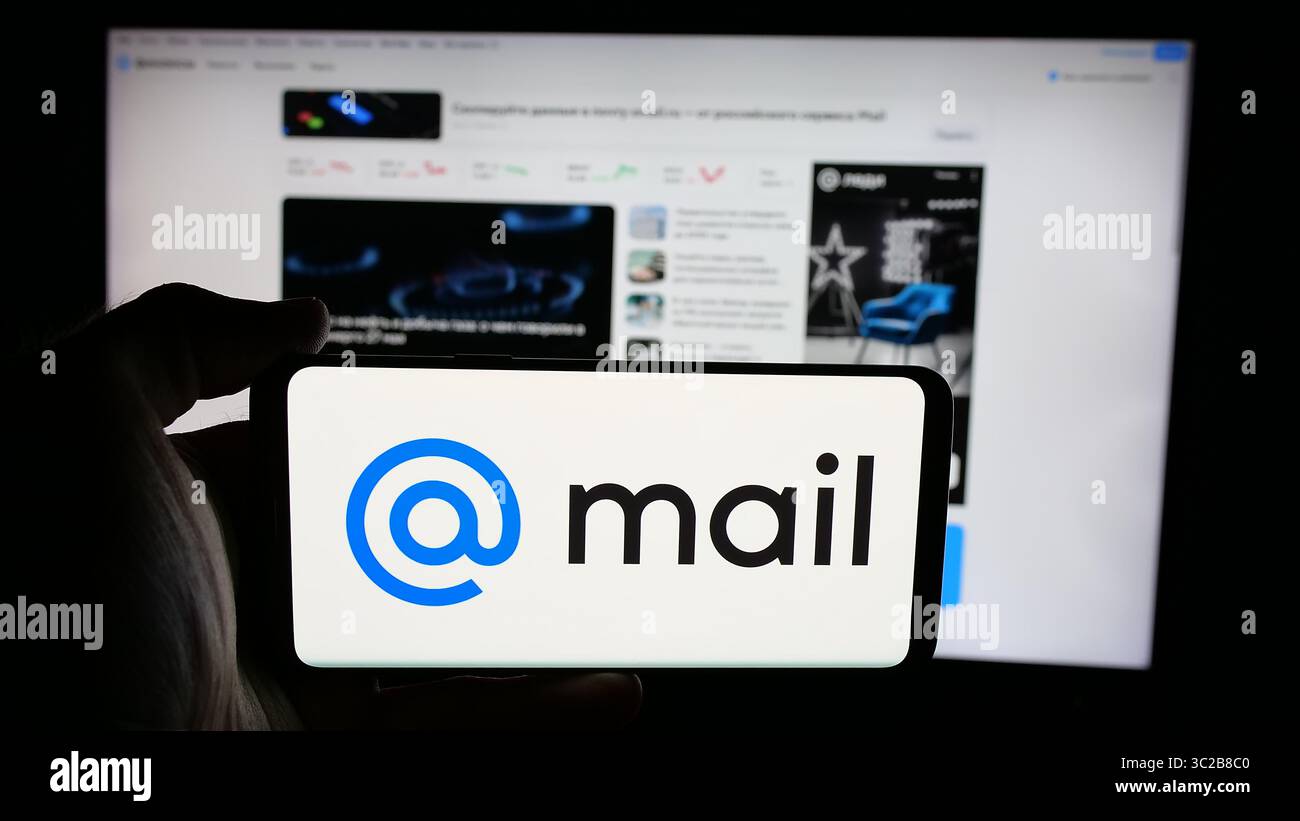 Stoccarda, Germania - 05-27-2025: Persona che tiene il cellulare con il logo della società tecnologica russa Mail.ru sullo schermo davanti alla pagina web. Foto Stock