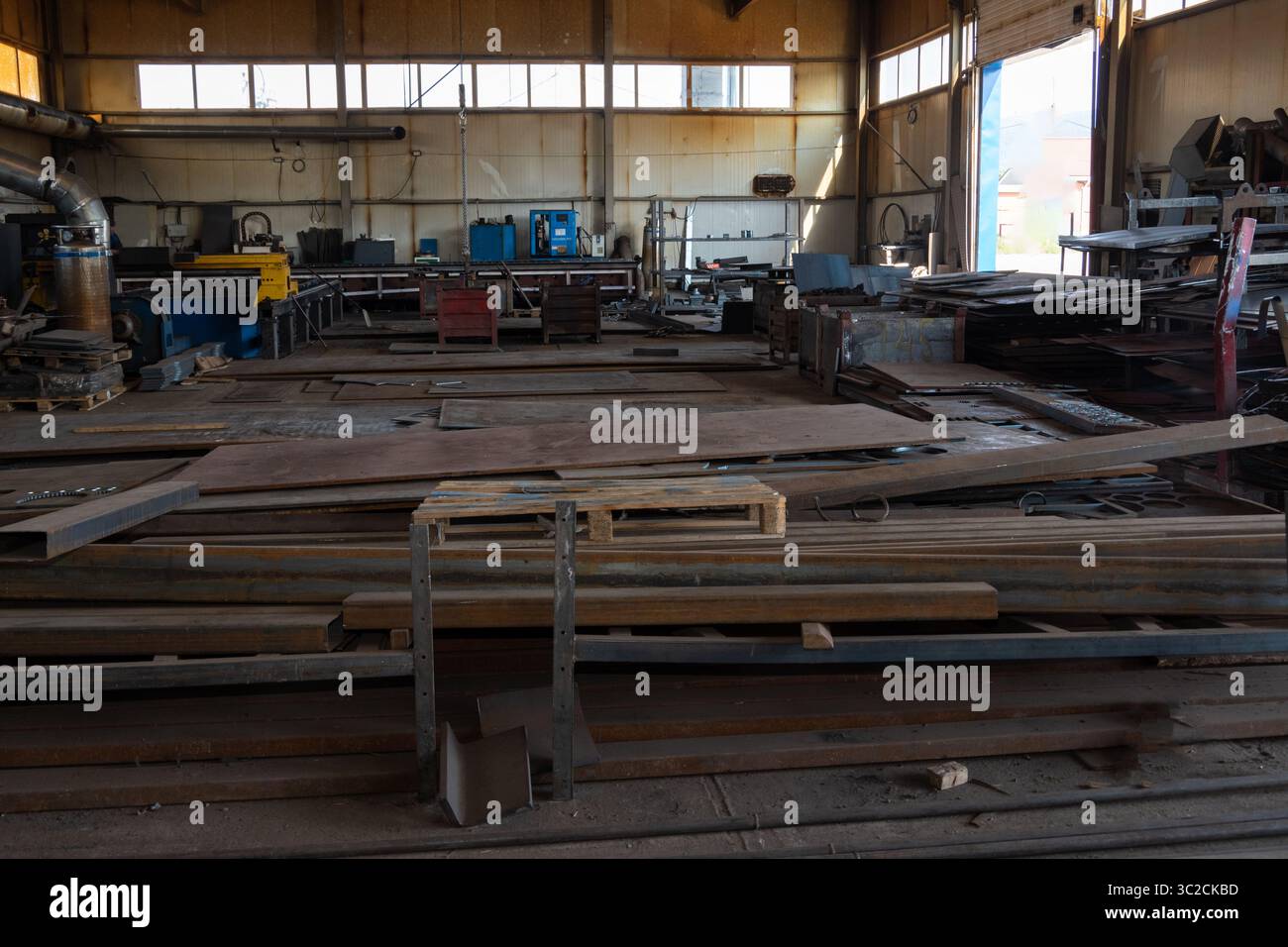 Ampi interni per officine industriali, lamiere e macchinari, illuminati da luce naturale, concetto di industria metallurgica Foto Stock