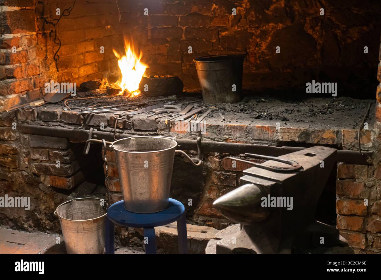 Un maestro fabbro al lavoro, forgiando la storia con il fuoco e l'acciaio in un laboratorio tradizionale. Foto Stock