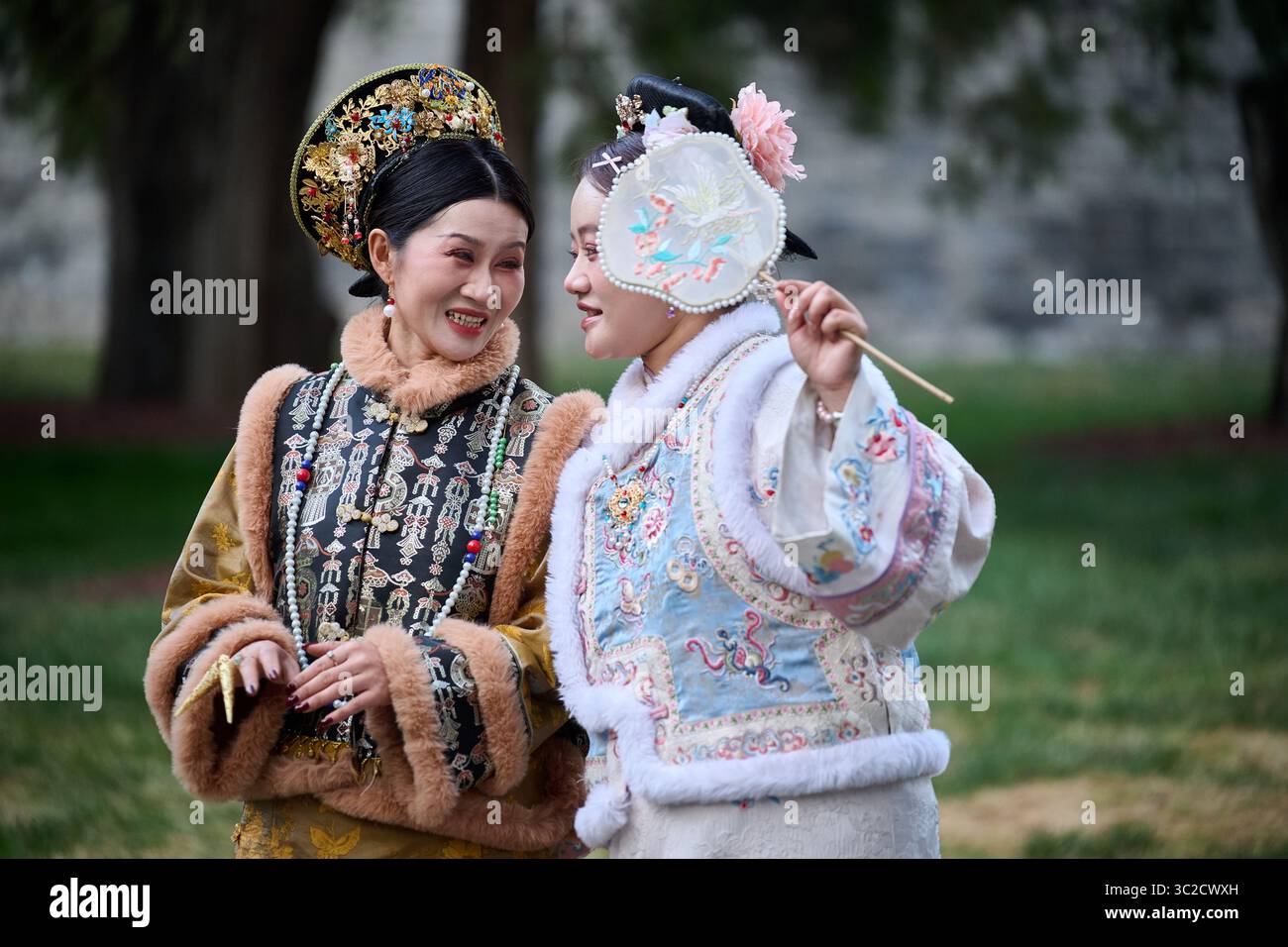 Le donne in abiti storici cinesi sorridono l'una all'altra nel parco Foto Stock