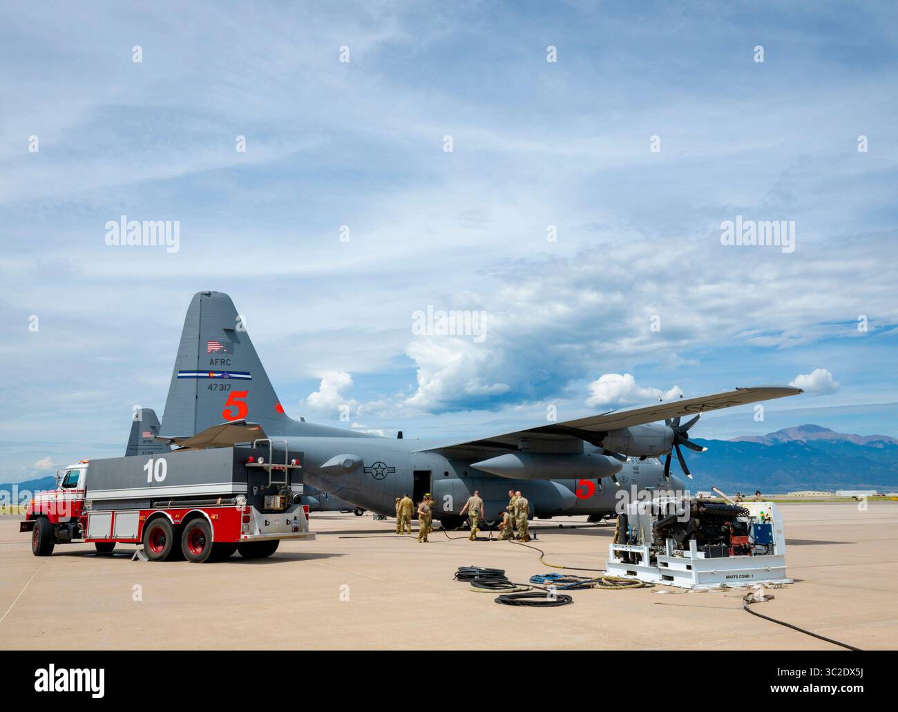 I vigili del fuoco con il 21st Civil Engineer Squadron e 302d Airlift Wing Airmen preparano il Modular Airborne Firefighting System per essere riempito di acqua e aria compressa a bordo di un aereo C-130H Hercules presso la Peterson Space Force base, Colorado, 22 luglio 2025. Le unità MAFFS sono progettate per un'implementazione rapida e un rifornimento rapido, fornendo una capacità di picco vitale durante le operazioni antincendio più impegnative. (Foto U.S. Air Force di Tech. Sergente Nicole Manzanares) Foto Stock