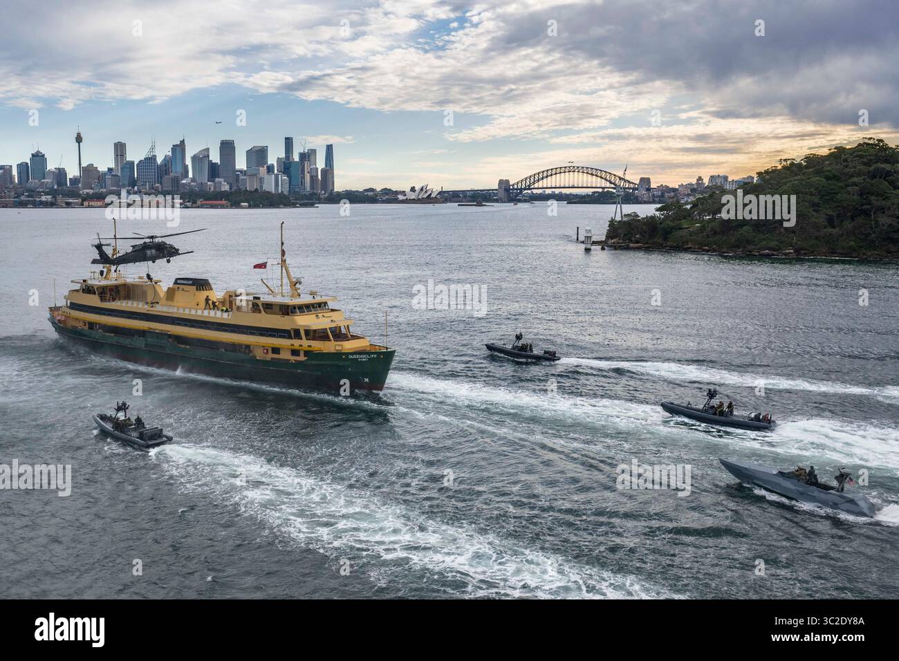 Operatori della US Naval Special Warfare (NSW), soldati dello Special Operations Command australiano e dei Royal Marine Commandos del Regno Unito dal 42 Commando intercettano una nave bersaglio simulata per visite, imbarco, ricerca e addestramento al sequestro utilizzando gommoni a scafo rigido e navi Combatant Craft Assault, insieme a un elicottero MH-60 dell'esercito statunitense assegnato al 160th Special Operations Aviation Regiment (Airborne) durante l'esercitazione Talisman Sabre 25 nel nuovo Galles del Sud, Australia, 8 luglio 2025. Il talismano Sabre è la più grande esercitazione militare bilaterale tra Australia e Stati Uniti, con mul Foto Stock