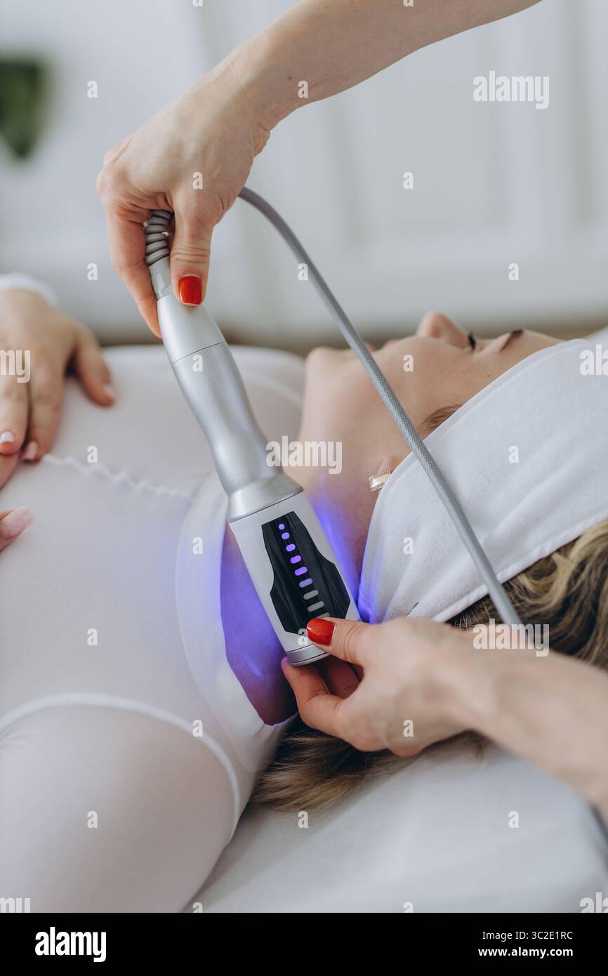 Una donna riceve un massaggio terapeutico endosferico anti-invecchiamento sul collo e sulla parte superiore del torace. Trattamento cosmetico non invasivo in una clinica di bellezza con un moderno Foto Stock