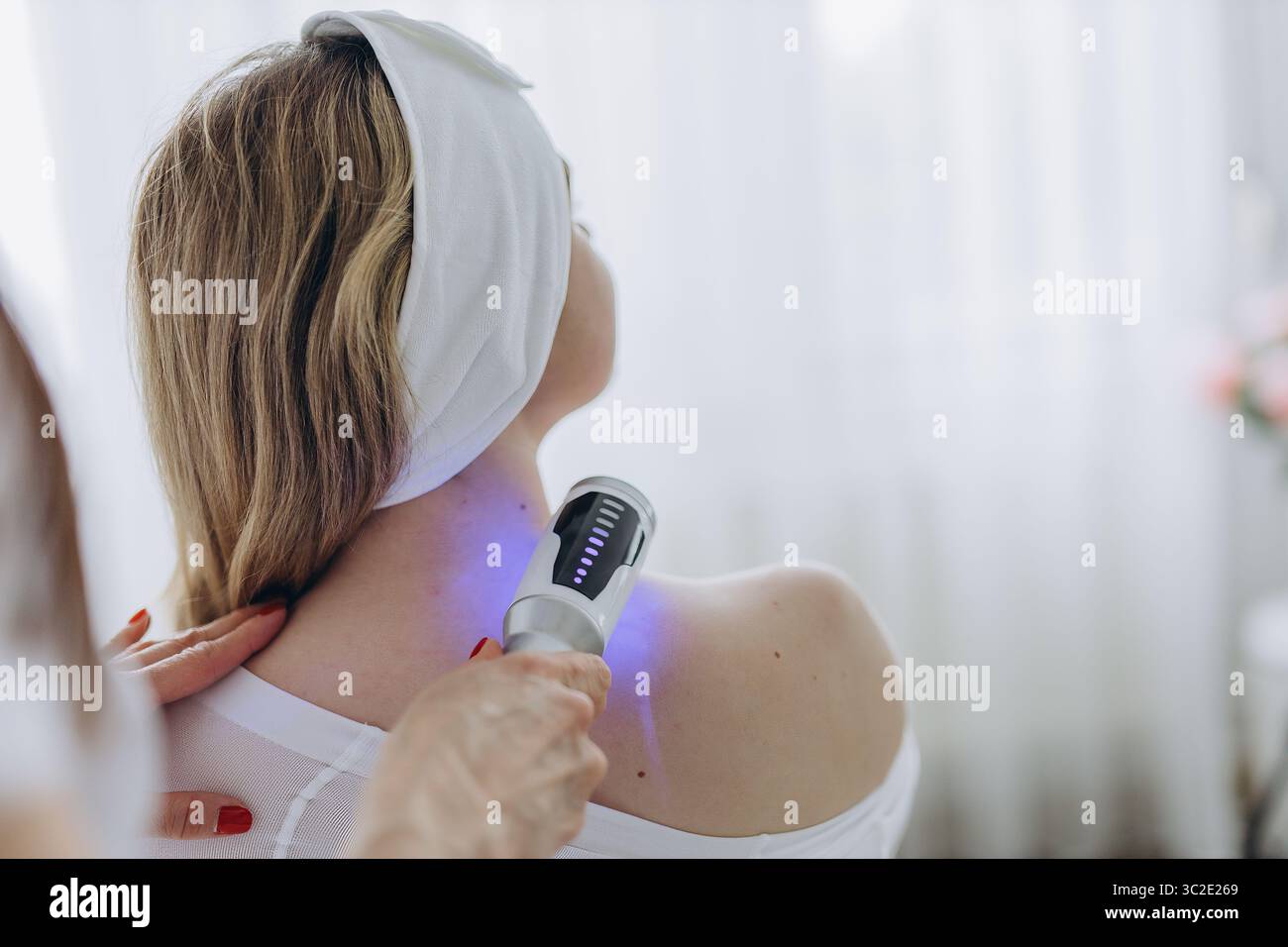 Una giovane donna che riceve un rilassante massaggio terapeutico endosferico sulla spalla in una clinica di bellezza. Trattamento corporeo non invasivo per il tono muscolare AN Foto Stock