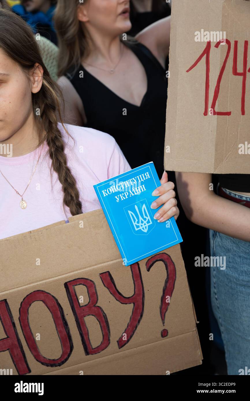 Kiev, Ucraina - 23 luglio 2025: I manifestanti si riuniscono in città per protestare contro una legge che mette a repentaglio l'indipendenza delle istituzioni anti-corruzione. I partecipanti hanno dei segni e mostrano una copia della Costituzione Ucraina, sottolineando la loro richiesta di trasparenza e responsabilità nella governance. Foto Stock