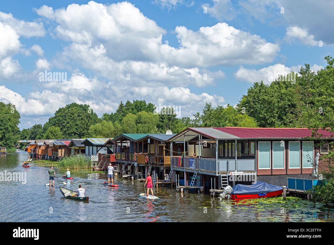 Canoa, stand-up paddle board, case per barche, case vacanza lungo il canale che collega il lago Mirow e il lago Zotzen, Mirow, i laghi del Meclemburgo, Germania Foto Stock