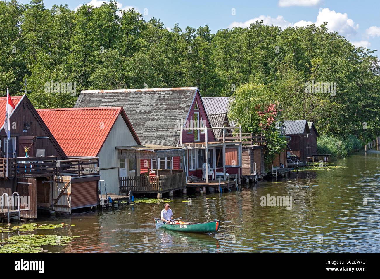 Canoa, case per barche, case per vacanze lungo il canale che collega il lago Mirow e il lago Zotzen, Mirow, Meclemburgo, Germania Foto Stock