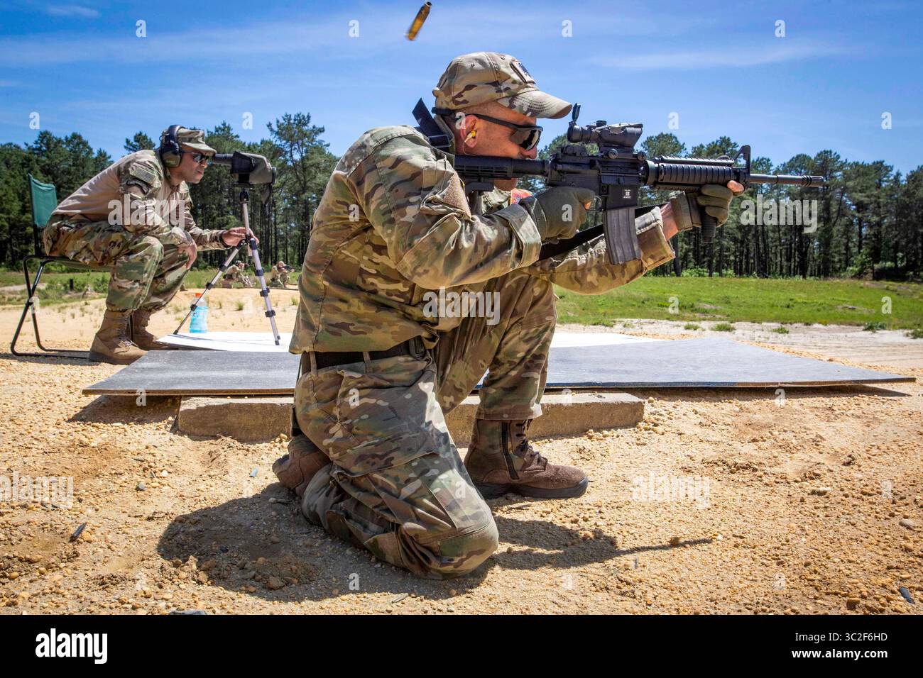 4 giugno 2019 - Joint base McGuire-Dix-Lakehurst, New Jersey, U.S. - U.S. Army staff Sgt. Brad T. Graham, a sinistra, istruttore, 1st Battalion, 254th Regional Training Institute (Combat Arms), New Jersey Army National Guard, osserva attraverso un campo di osservazione come un soldato delle forze speciali dell'esercito albanese spara una carabina M4 durante l'addestramento di tiro designato dalla squadra presso Joint base McGuire-Dix-Lakehurst, N. 2019 giugno. Dal 2 al 12 giugno, il 254th addestrò i soldati delle forze speciali sulla precisione a lungo raggio e altre abilità di combattimento. Il National Guard State Partnership Program è un dipartimento degli Stati Uniti Foto Stock