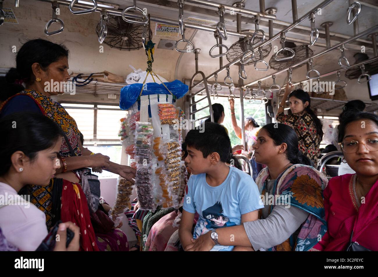 India, Mumbai, donne in carrozza per sole donne, compresa una donna che vende gioielli economici Foto Stock