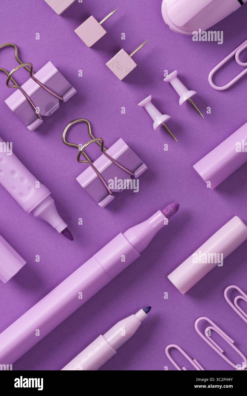 Penne in feltro viola per cancelleria, pennarelli, appunti, graffette, spille su sfondo viola Foto Stock