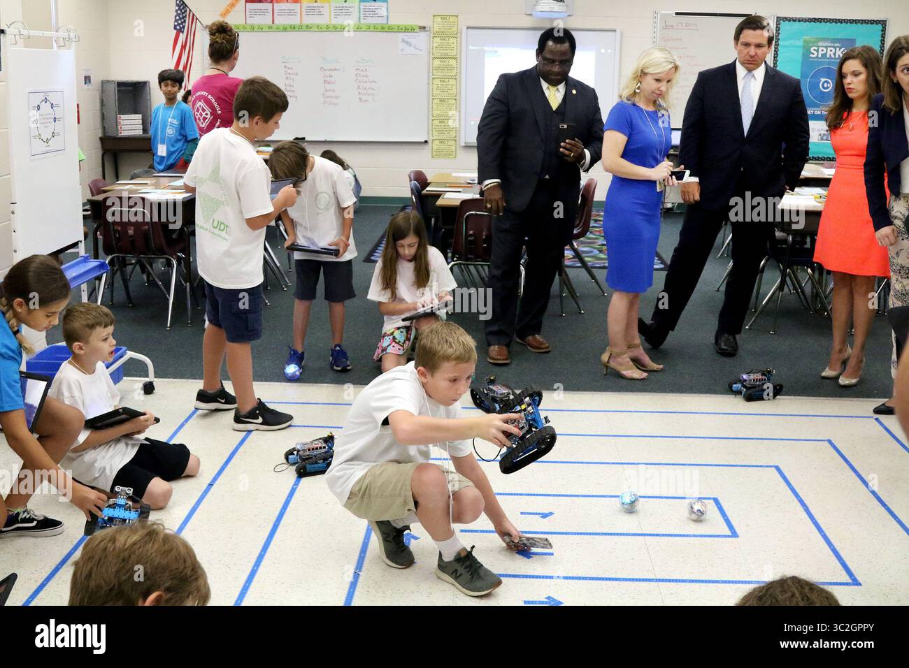 17 giugno 2019 - largo, Florida, Stati Uniti - Rep. Wengay Newton (distretto 70), centro, si unisce a Laura Spence, specialista STEM K-12 presso la Pinellas County School, destra, e il governatore della Florida Ron DeSantis e il membro del Consiglio scolastico della contea di Pinellas Lisa cane (distretto 2), giusto, in una classe del campo estivo STEM di quarta-quinta elementare dove gli studenti, tra cui Benjamin Dyer, di nove anni, hanno lavorato con mBots che gli studenti hanno costruito da zero (li programmano utilizzando la programmazione a blocchi sul computer e poi il robot esegue il compito assegnato) durante una visita lunedì (6/17/19) alla scuola Ridgecrest Elementary School Foto Stock