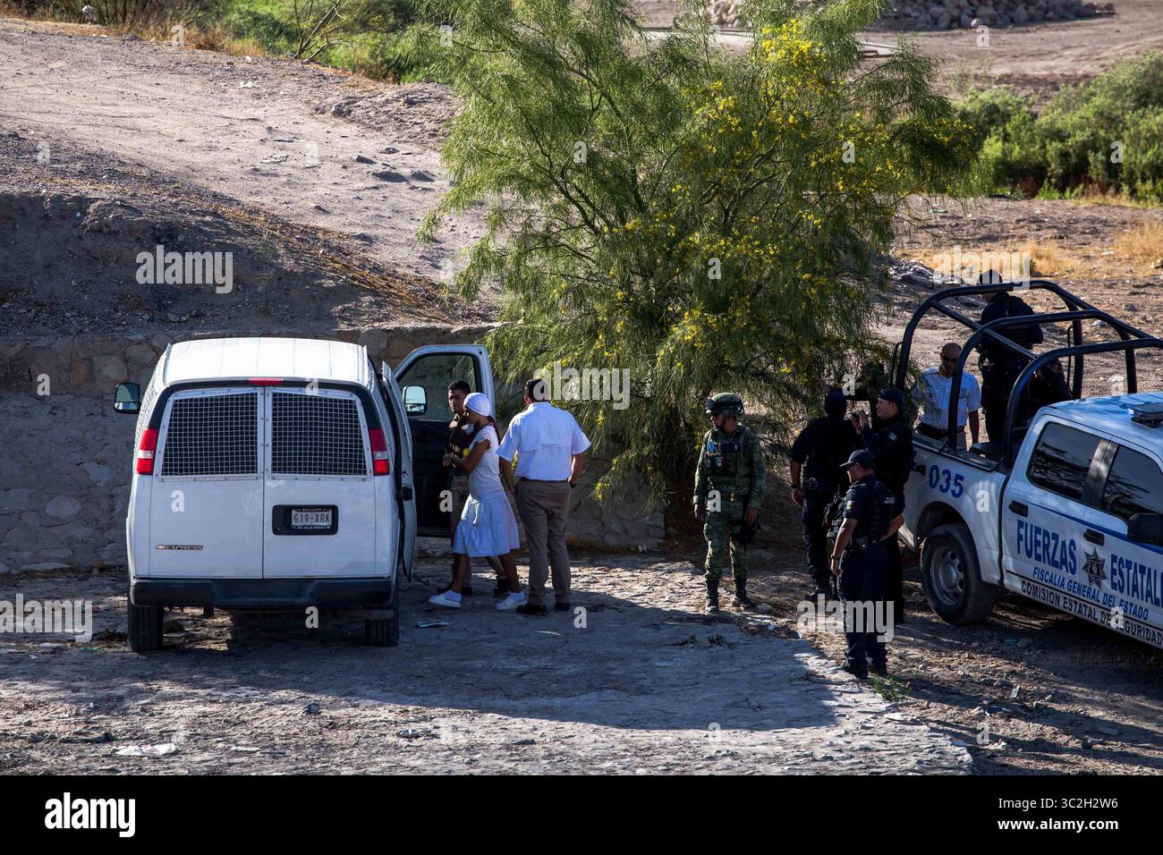 18 giugno 2019 - il personale dell'Instituto Nacional de Migraciâ del Messico, l'agenzia messicana per l'immigrazione, carica due migranti in furgoni detenuti da personale militare del EjÅ½rcito Mexicano, l'esercito messicano, lungo il Rio grande a Ciudad Juâ€rez, Chihuahua, MÅ½xico. I migranti furono sospettati di aver tentato di attraversare illegalmente il Rio grande negli Stati Uniti attraverso El Paso, Texas. Secondo il personale militare messicano, hanno iniziato a pattugliare il confine a Ciudad Juâ€rez il 16 giugno con l'intenzione di prevenire l'immigrazione clandestina negli Stati Uniti. (Immagine di credito: © Joel Foto Stock