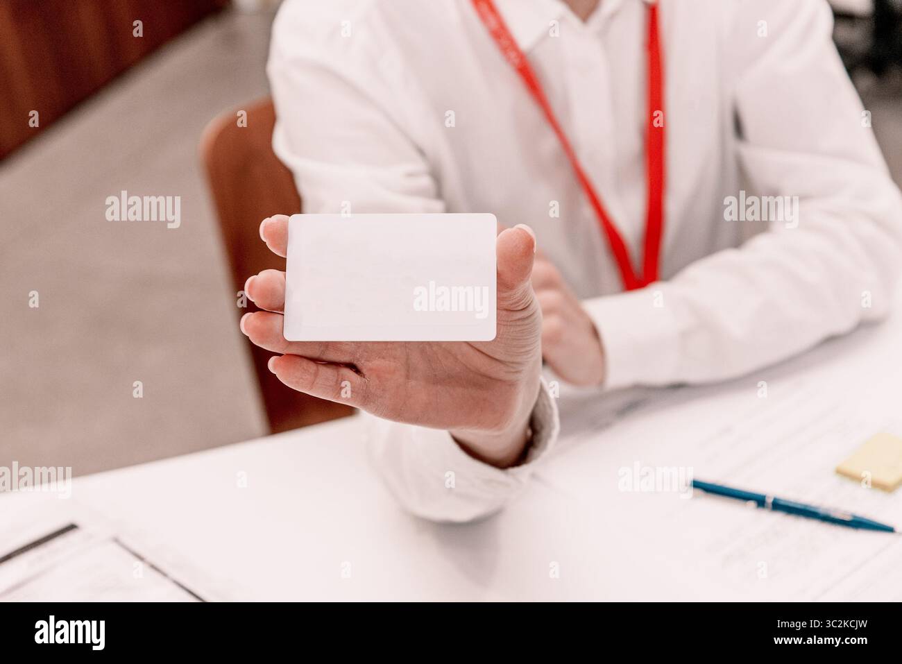 Donna d'affari che tiene in mano un mockup bianco per biglietti da visita con spazio per le informazioni testuali Foto Stock