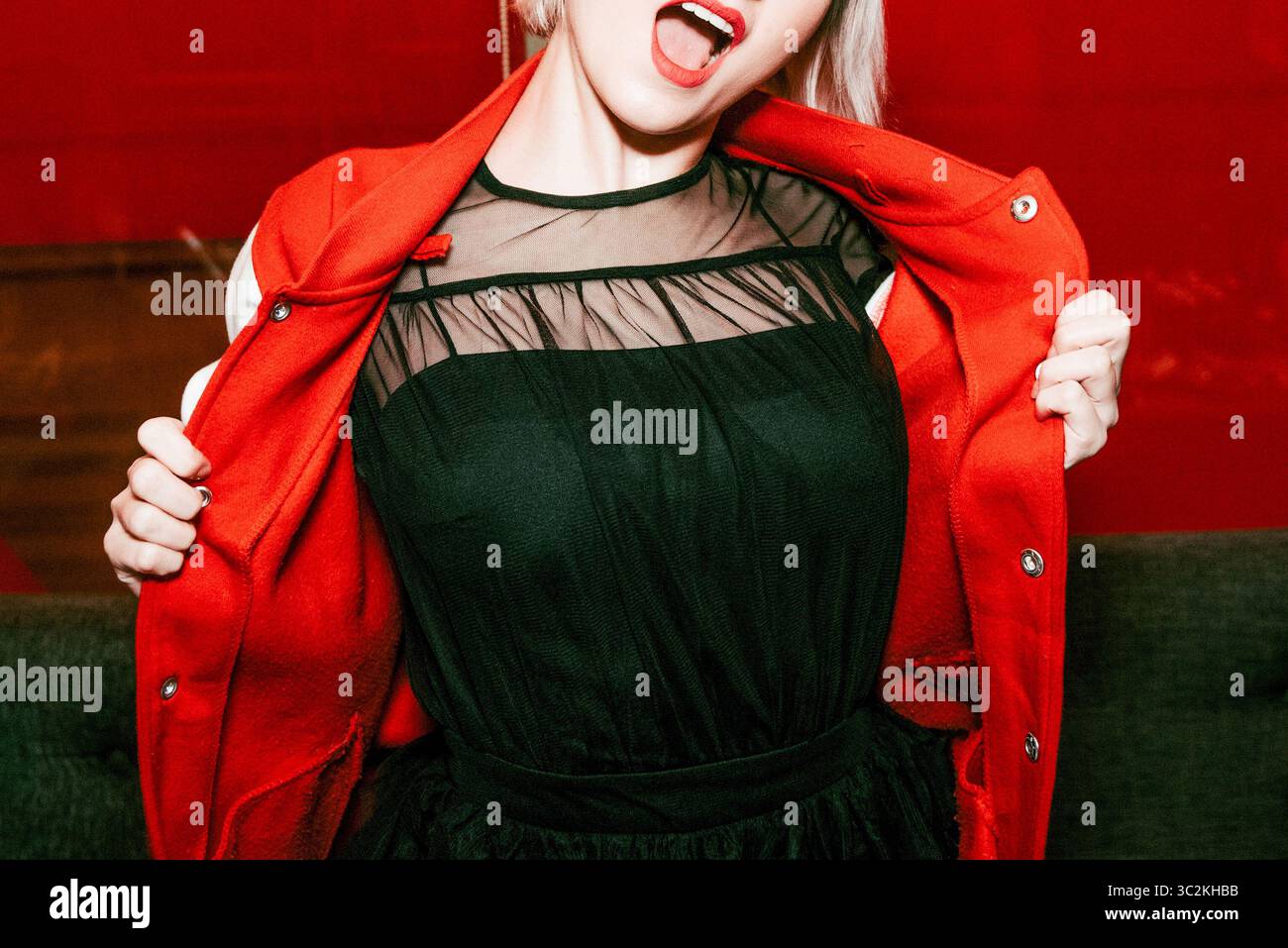 Giovane donna allegra e bella che indossa un elegante abito da bomber rosso Foto Stock