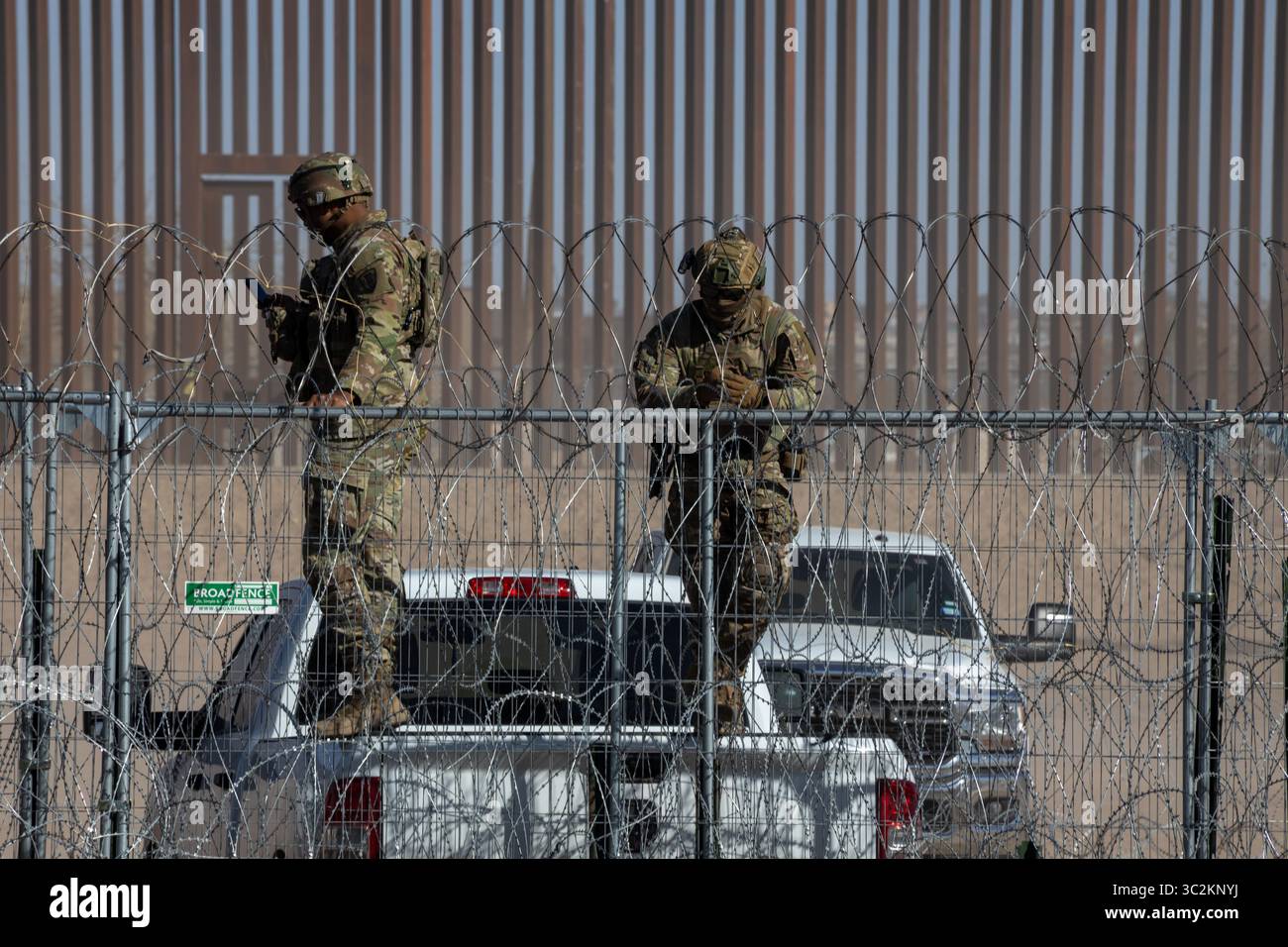 Il personale militare al confine di Ciudad Juarez controlla un'area protetta con filo a fisarmonica e un muro di metallo. Foto Stock