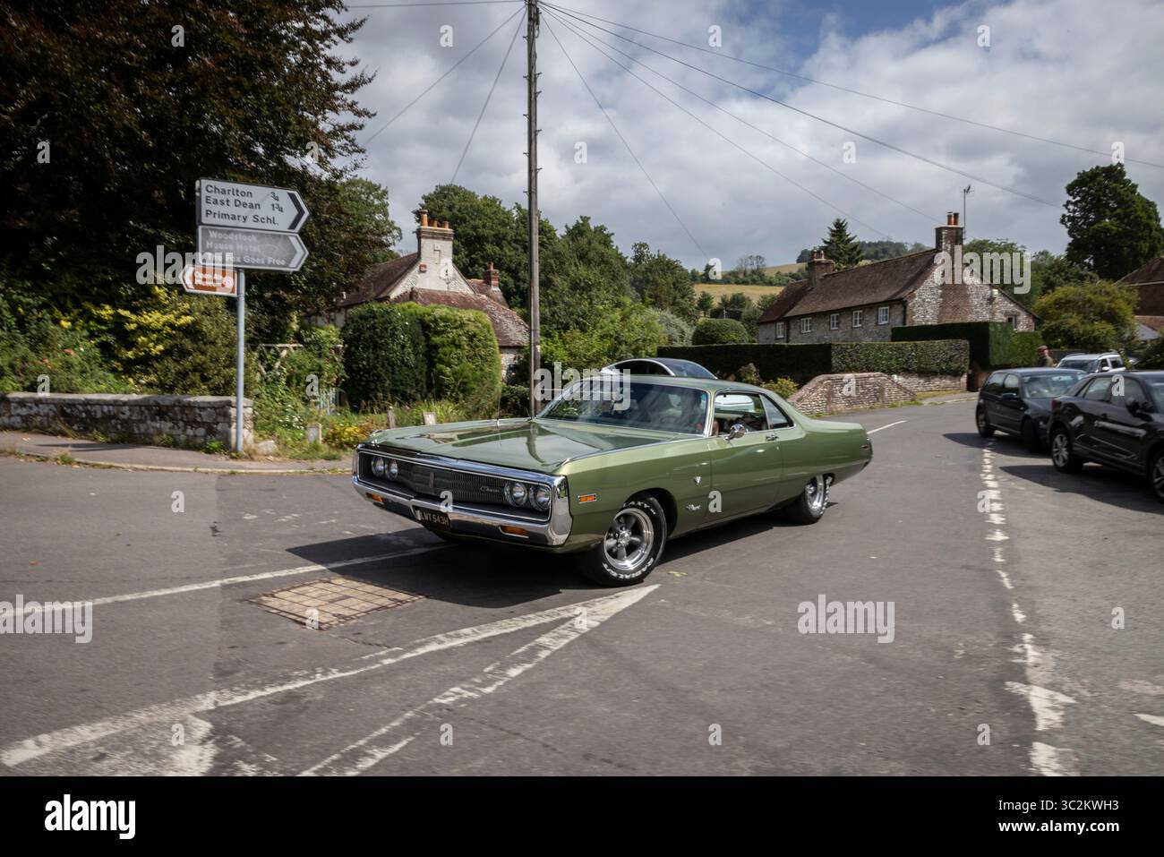 1970 CHRYSLER NEWPORT COUPÉ, auto full-size a due porte prodotta da Chrysler come parte della loro linea Newport, che attraversa un villaggio inglese, nel Regno Unito Foto Stock