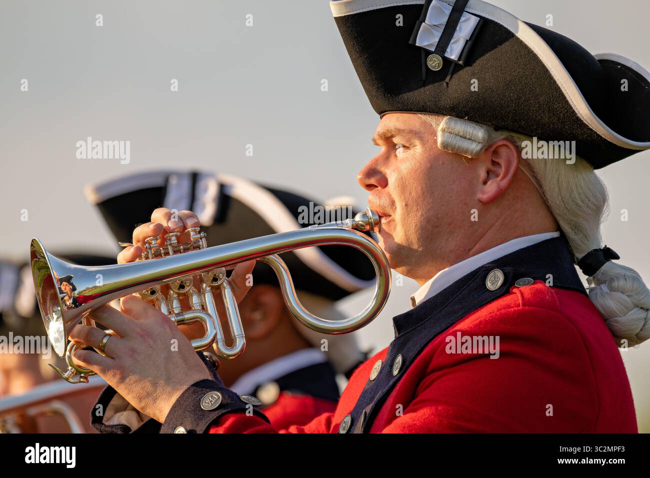 US Army Old Guard Fife and Drum Corps gioca a Rotary Valve Bugle Arlington va // ARLINGTON, Virginia — Un soldato della Old Guard Fife e Drum Corps dell'esercito americano gioca un bugle valvo, noto anche come tromba di cavalleria, durante il Twilight Tattoo dell'esercito americano. Questo strumento in ottone è dotato di valvole a pistone e di una caratteristica forma curva, a differenza delle tradizionali trombe. Il musicista, in un'uniforme dell'epoca dell'Esercito continentale, fa parte dell'Old Guard Fife and Drum Corps, che mette in mostra le tradizioni musicali militari. La Vecchia Guardia è l'unità cerimoniale ufficiale dell'esercito e ospita la pagea militare estiva Twilight Tattoo Foto Stock