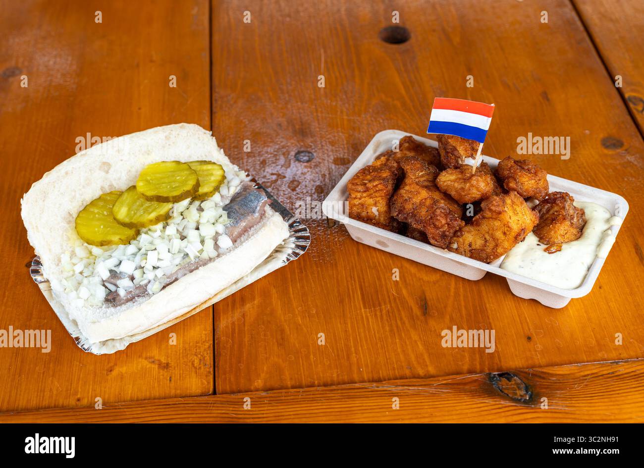 Piatti tradizionali olandesi a base di pesce, Herring Sandwich, conosciuto nei Paesi Bassi come Broodje Haring, e Kibbeling affiancati Foto Stock