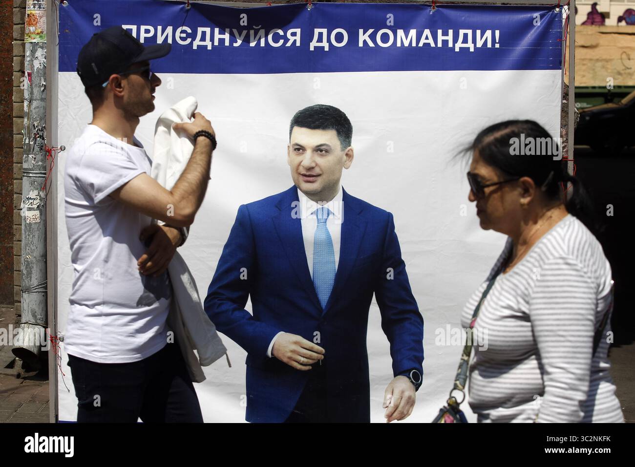 16 luglio 2019 - Kiev, Ucraina - la gente passa davanti a un manifesto della campagna elettorale del primo ministro ucraino Volodymyr Groysman a Kiev. Le elezioni anticipate del parlamento si svolgeranno in Ucraina il 21 luglio 2019. Secondo i sondaggi d'opinione, sulle elezioni parlamentari ucraine del 2019 5 partiti potranno entrare nel Parlamento ucraino: Il partito del presidente ucraino Volodymyr Zelensky chiamato Servo del popolo con il 41,5%, piattaforma di opposizione filo-russa - per la vita con il 12,5%, partito vocale della rock star Ucraina Svyatoslav Vakarchuk con il 8,8%, solidarietà europea dell'ex ucraino Foto Stock 16 luglio 2019 - Kiev, Ucraina - la gente passa davanti a un manifesto della campagna elettorale del primo ministro ucraino Volodymyr Groysman a Kiev. Le elezioni anticipate del parlamento si svolgeranno in Ucraina il 21 luglio 2019. Secondo i sondaggi d'opinione, sulle elezioni parlamentari ucraine del 2019 5 partiti potranno entrare nel Parlamento ucraino: Il partito del presidente ucraino Volodymyr Zelensky chiamato Servo del popolo con il 41,5%, piattaforma di opposizione filo-russa - per la vita con il 12,5%, partito vocale della rock star Ucraina Svyatoslav Vakarchuk con il 8,8%, solidarietà europea dell'ex ucraino Foto Stock