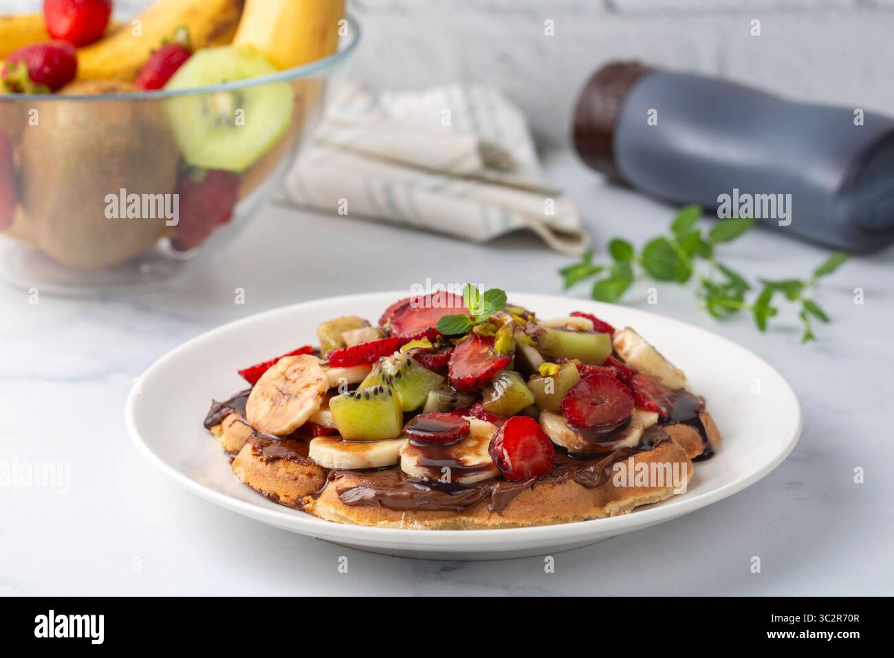 Waffle alla frutta, banane al cioccolato, fragole, patatine al cioccolato, waffle turchi fatti a mano e pistacchi Foto Stock