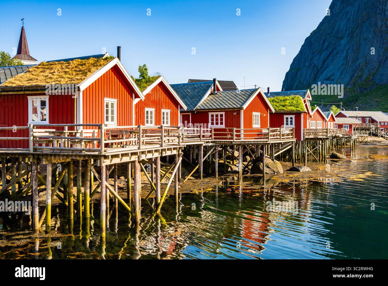 Case rosse di tipo tradizionale utilizzate dai pescatori nel villaggio di Reine sull'isola di Moskenesoy in estate, isole Lofoten, Norvegia Foto Stock