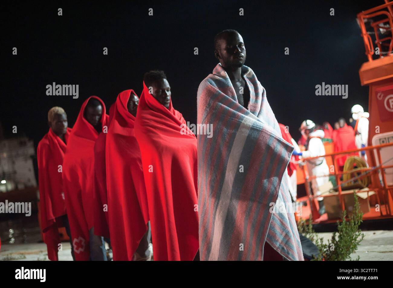 Il 5 agosto 2019, Malaga, Spagna: migranti sono visti in attesa di camminare verso una situazione di emergenza umanitaria in stallo dopo il loro arrivo al porto di Malaga. Spagna's Maritime Rescue service salvato un totale di 96 migranti (di loro, 10 donne e 9 maghrebins migranti), a bordo di due gommoni attraversando Mare di Alboran e li ha portati al porto di Malaga, dove sono stati assistiti dalla Croce Rossa spagnola. In accordo con la spagnola fonti governative, il numero dei migranti nel tentativo di raggiungere le coste spagnole nel 2019 è sceso a 40,2% con un totale di 13.326 migranti nel confronto con l anno precedente 2018. (Credito Im Foto Stock
