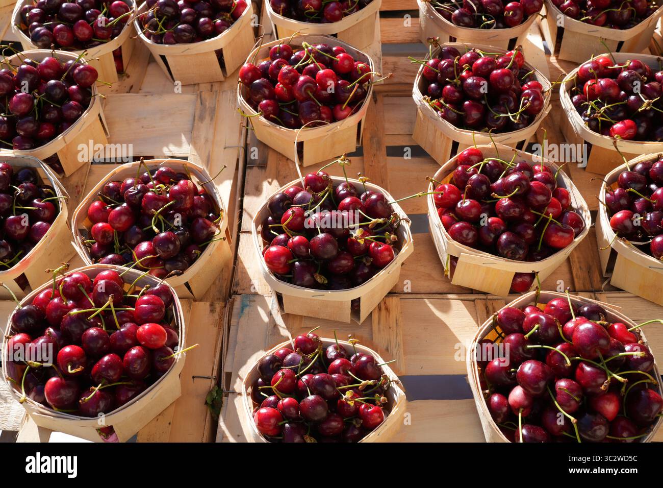 Cesti di ciliegie mature in un mercato agricolo francese visto dall'alto Foto Stock