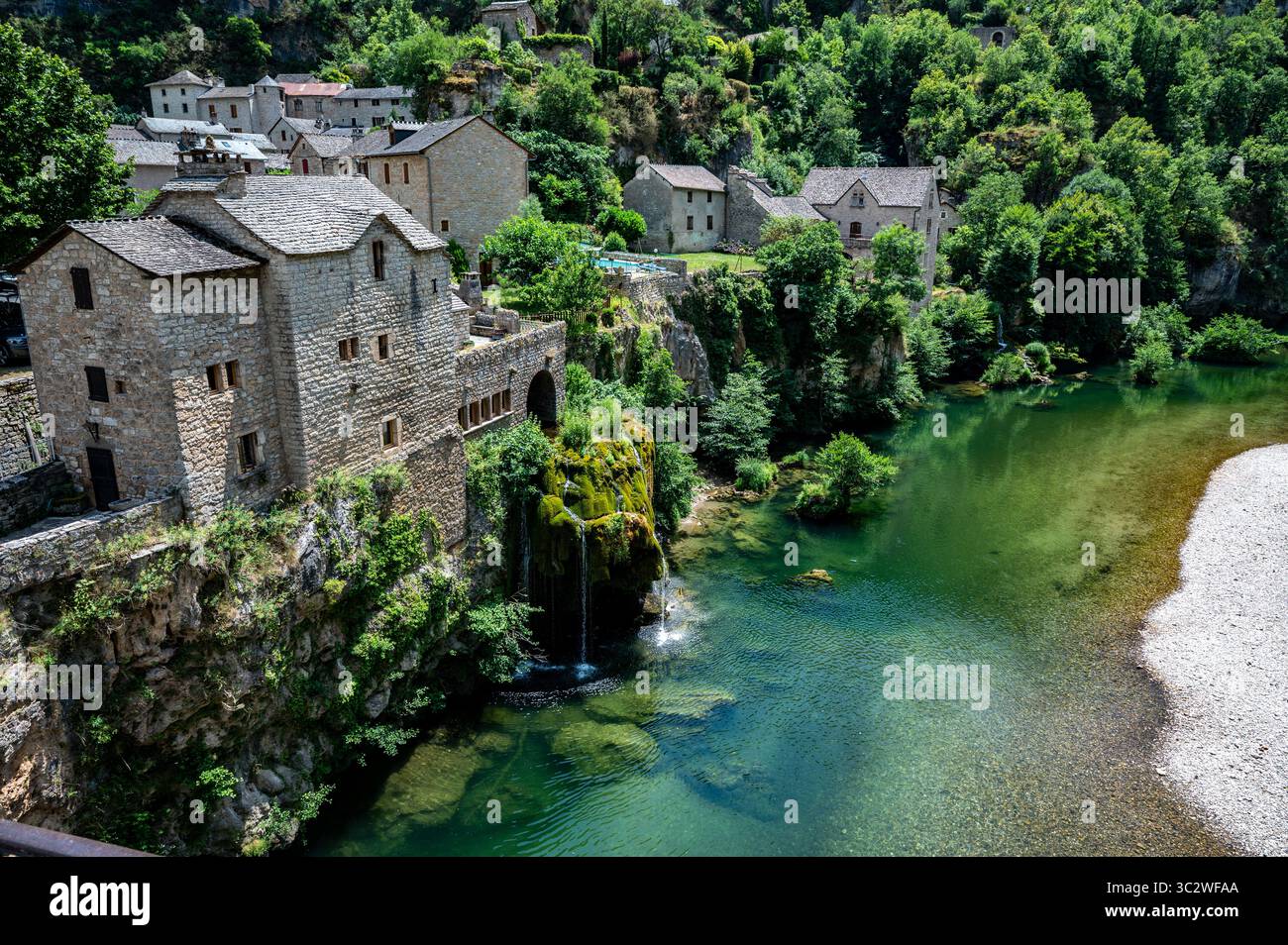 Saint‑Chély‑du‑Tarn: Villaggio sul fiume con cascata nelle Gole del Tarn, Francia Foto Stock