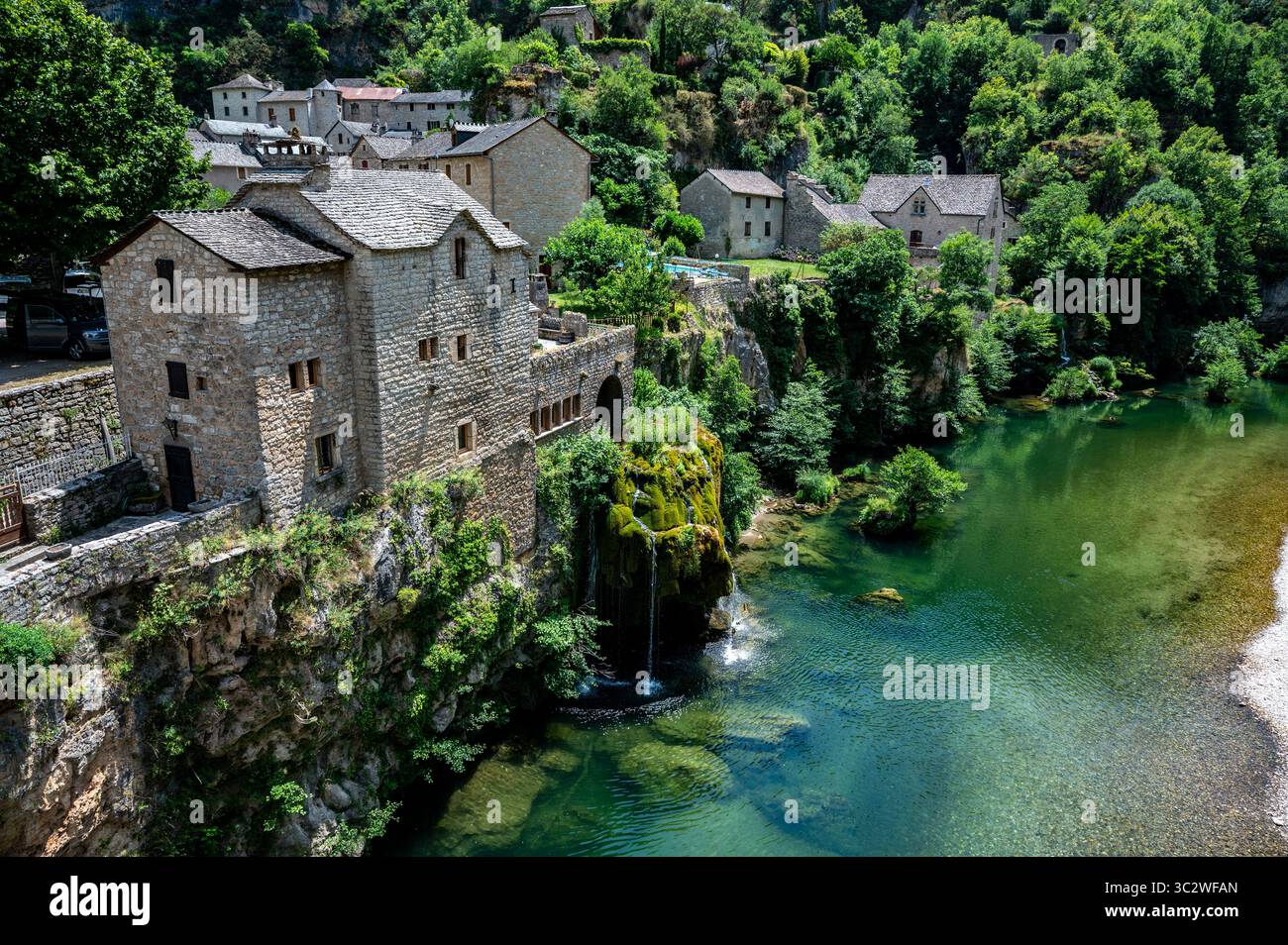 Saint‑Chély‑du‑Tarn: Villaggio sul fiume con cascata nelle Gole del Tarn, Francia Foto Stock