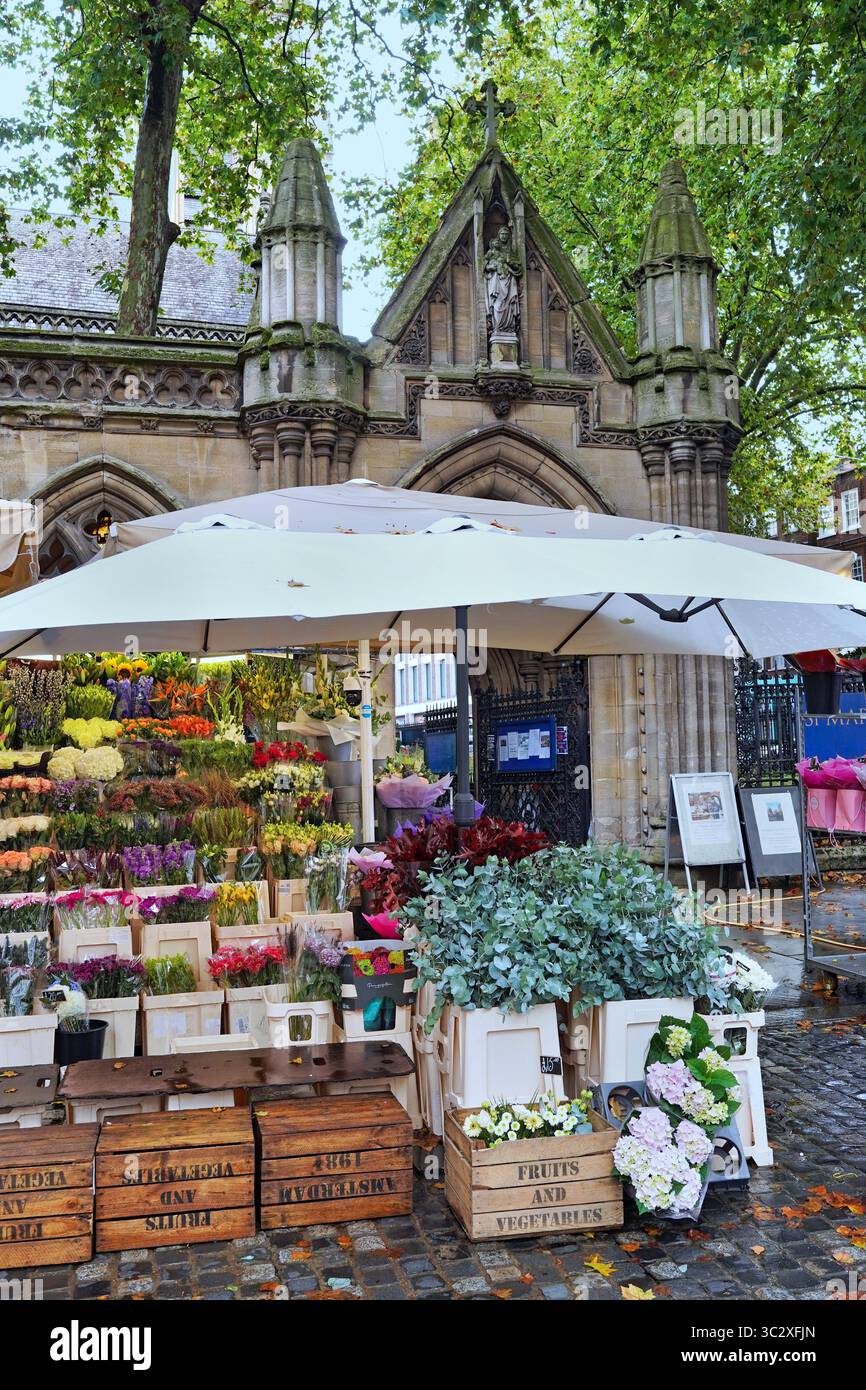 Flower stand di fronte a una chiesa gotica in Kensington High Street a Londra Foto Stock