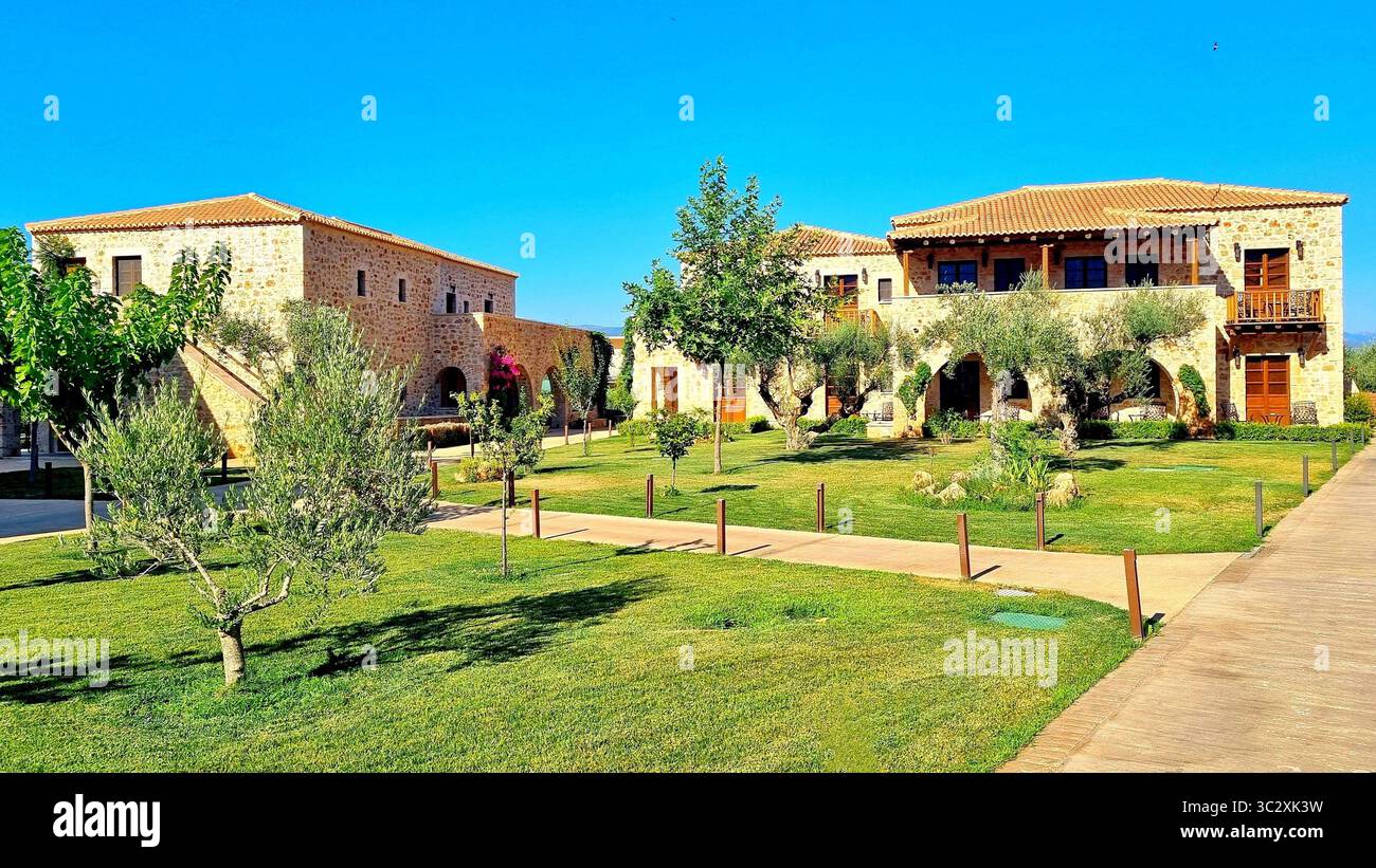 Area verde con case in pietra in stile antico nel cortile del lussuoso hotel greco Mystras Grand Palace Resort & Spa Foto Stock