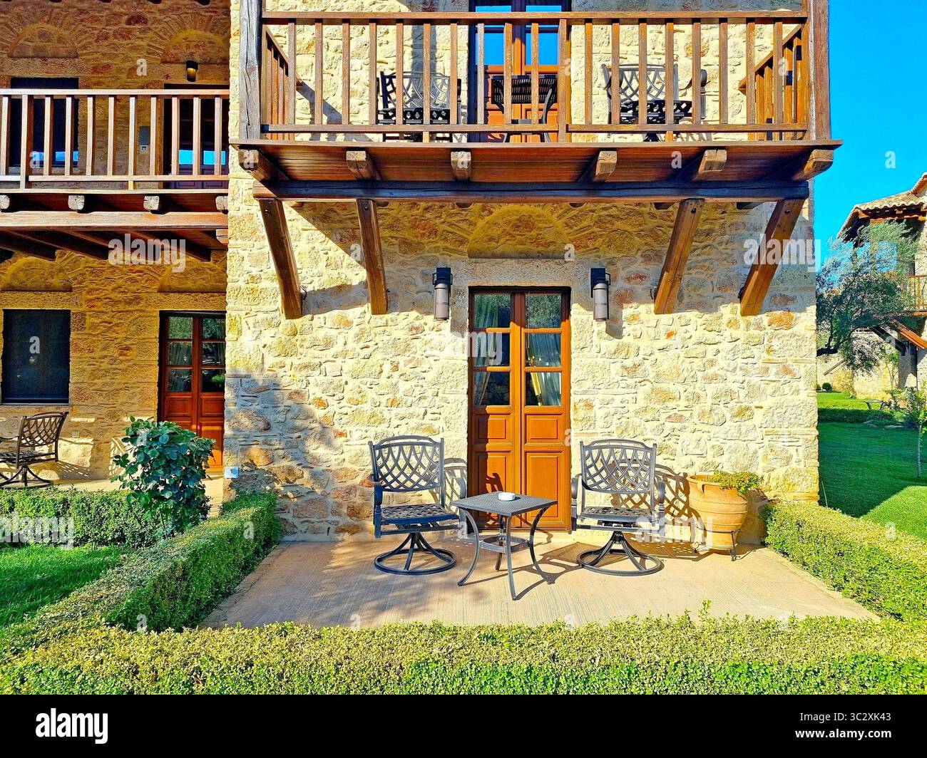 Frammento di facciata di edificio in pietra con balcone e patio nel lussuoso hotel greco Mystras Grand Palace Resort & Spa Foto Stock