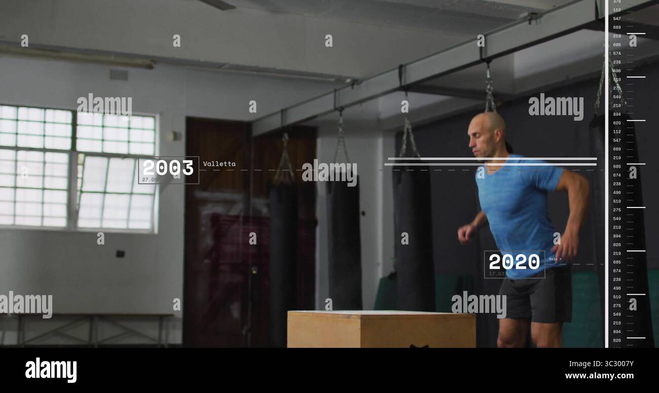 Salto maschile in un abbigliamento atletico esecuzione di box plyometrico in palestra con sacchetti di punzonatura, spazio copia Foto Stock