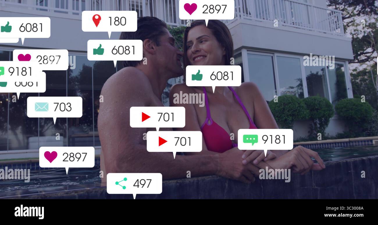 Donna pendente in bikini rosa e uomo senza camicia sorridente a bordo piscina a casa con icone digitali fluttuanti Foto Stock