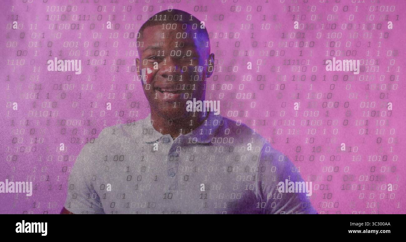 Uomo afroamericano sorridente che indossa una polo grigia in piedi in studio, con sovrapposizione codice binario Foto Stock