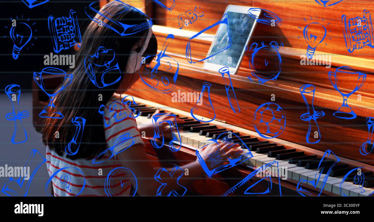 Ragazza cinese che suona il pianoforte a casa, indossa le cuffie, camicia a righe con tablet e scarabocchi blu Foto Stock
