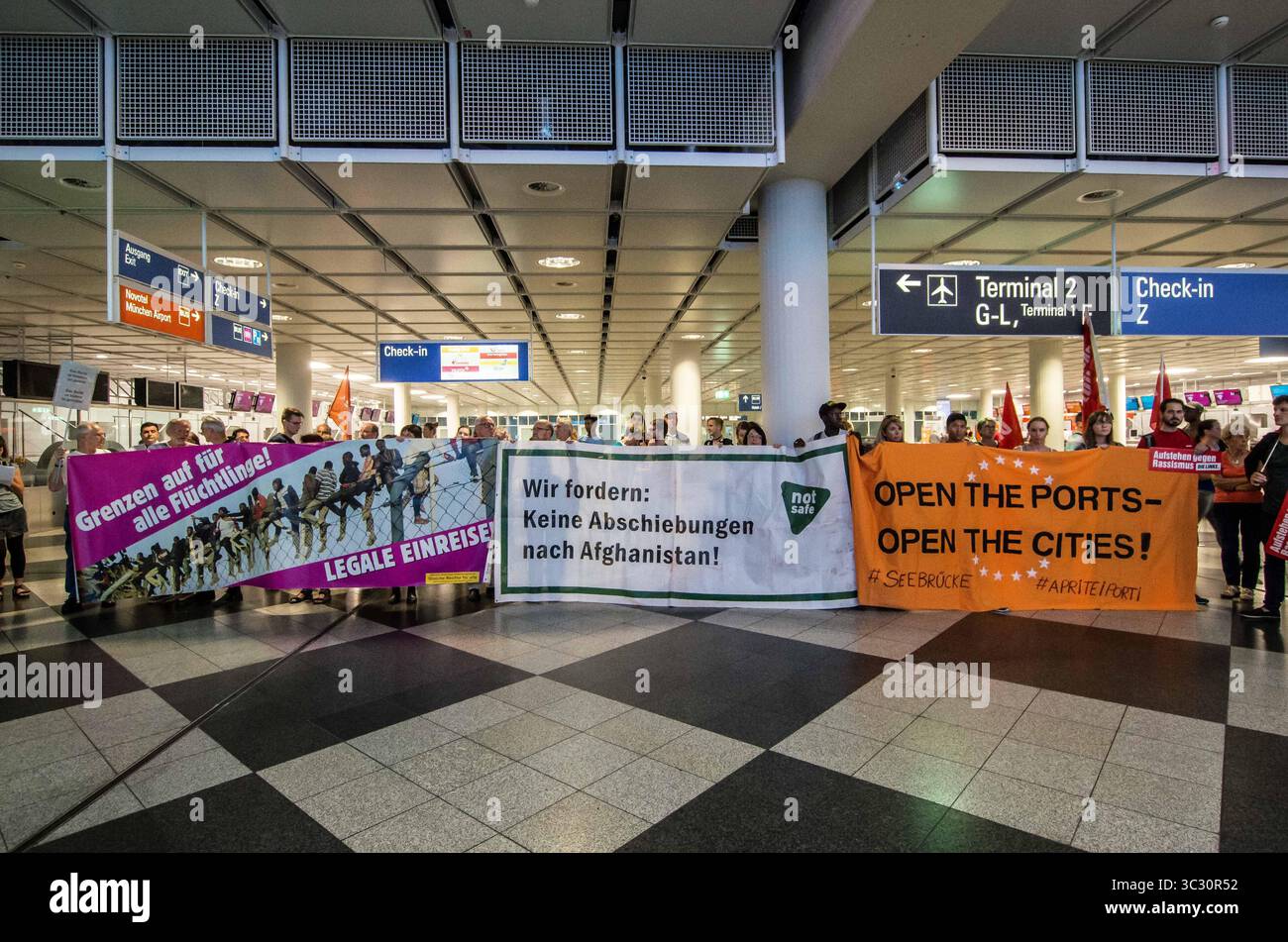 27 agosto 2019, Monaco di Baviera, Germania: "Frontiere aperte per i rifugiati". In concomitanza con una deportazione di massa dalla Germania in Afghanistan, 100 rifugiati, migranti e attivisti hanno organizzato una protesta contro la politica dei rifugiati di Germanyâ all'aeroporto internazionale di Monaco. Tra le critiche si annoverano l'uso di Ankerzentren (centri di ancoraggio) progettato per sequestrare rifugiati e migranti dalla società, valutazioni inique dell'asilo da parte del BAMF, la convenzione Dublino III, e la controversa terra di â œsafe di originâ decisioni che sono state utilizzate per accelerare le deportazioni nelle zone di guerra. (Credito Foto Stock