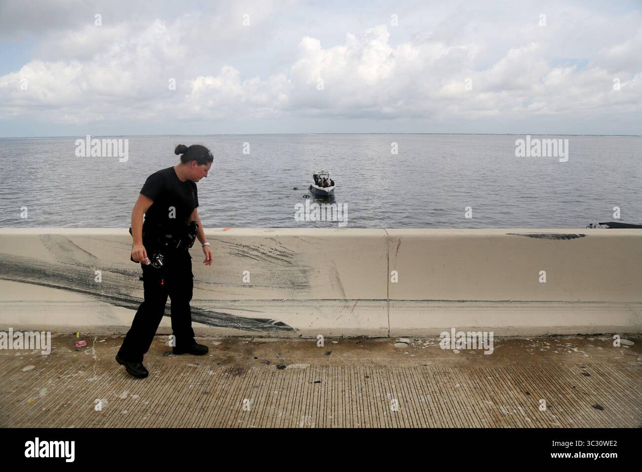 28 agosto 2019, Tampa, Florida, Stati Uniti: Il caporale della FHP Heather Barnhart esamina i segni su una barriera al punto di uscita dove un SUV ha ribaltato nella baia di Tampa al largo delle corsie sud della i-275 sul ponte Howard Frankland mercoledì 28 agosto 2019 a Clearwater. Un SUV bianco si stava dirigendo a sud in modo spericolato quando il conducente cambiò corsia e si scontrò con una Ford F-150, secondo la Florida Highway Patrol. La sezione posteriore destra del SUV ha colpito la parte anteriore del pick-up, facendo ruotare il SUV, capovolgerlo un certo numero di volte e ribaltare la barriera in acqua, ha detto i soldati. (Immagine di credito: © Foto Stock