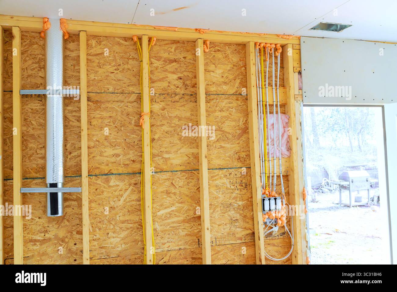 Il cablaggio di isolamento viene aggiunto alla nuova casa nei giorni lavorativi nei sobborghi. Foto Stock