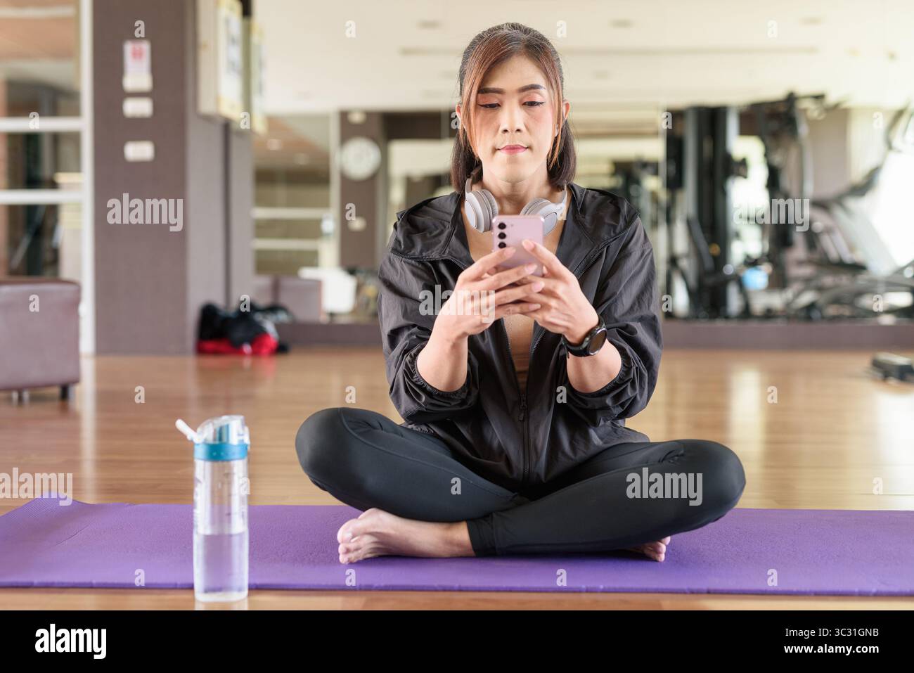 Donna transgender negli anni '40 pratica yoga in un ambiente fitness in palestra, che rappresenta flessibilità, equilibrio e benessere Foto Stock