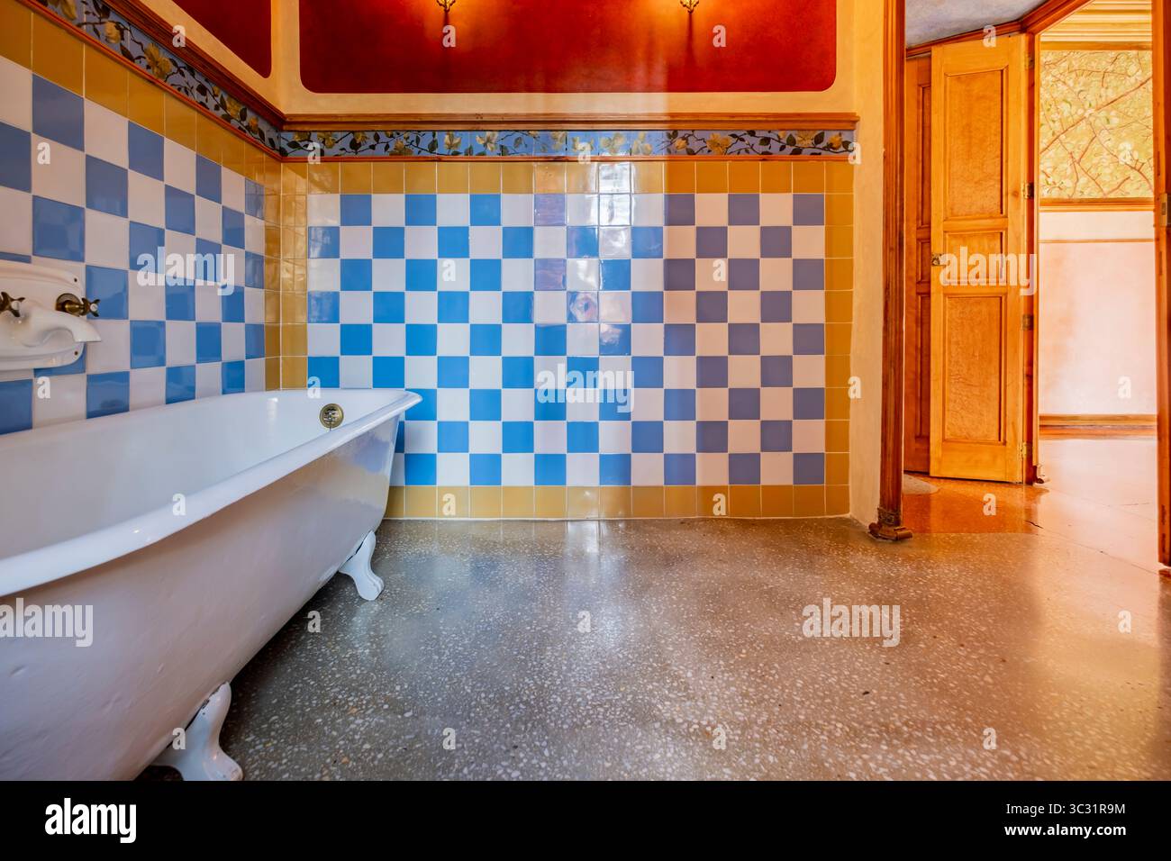 Vivace bagno storico di Casa Vicens che conduce ad un'altra stanza, che mostra l'arte modernista di Antoni Gaudí. Vasca da bagno a zampa d'artiglio, piastrelle in ceramica colorata Foto Stock