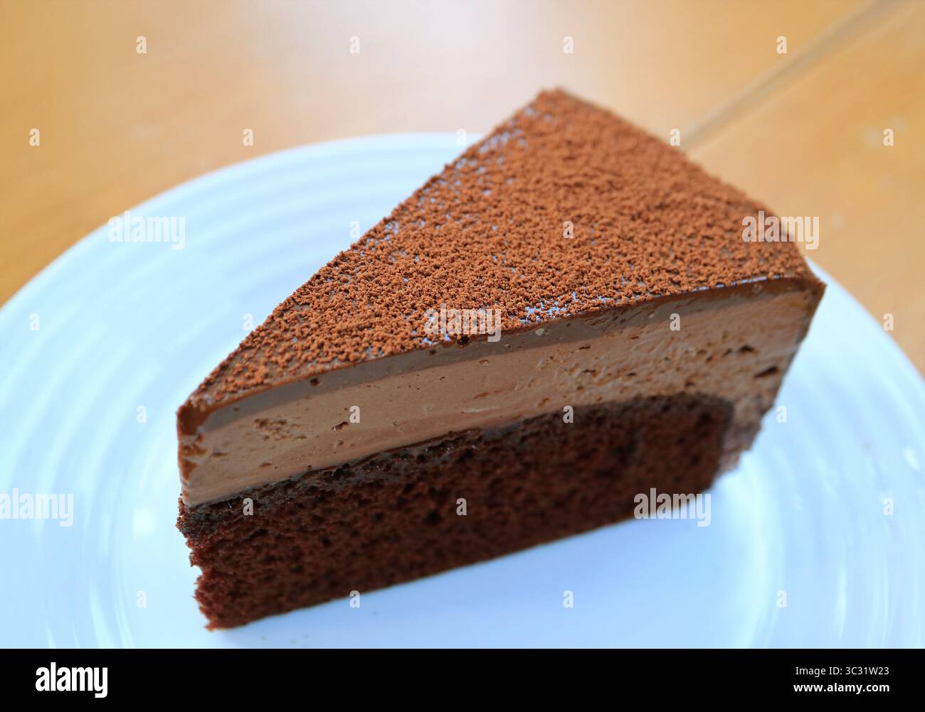 Una fetta di gustosa mousse di cioccolato servita su un tavolo di legno Foto Stock