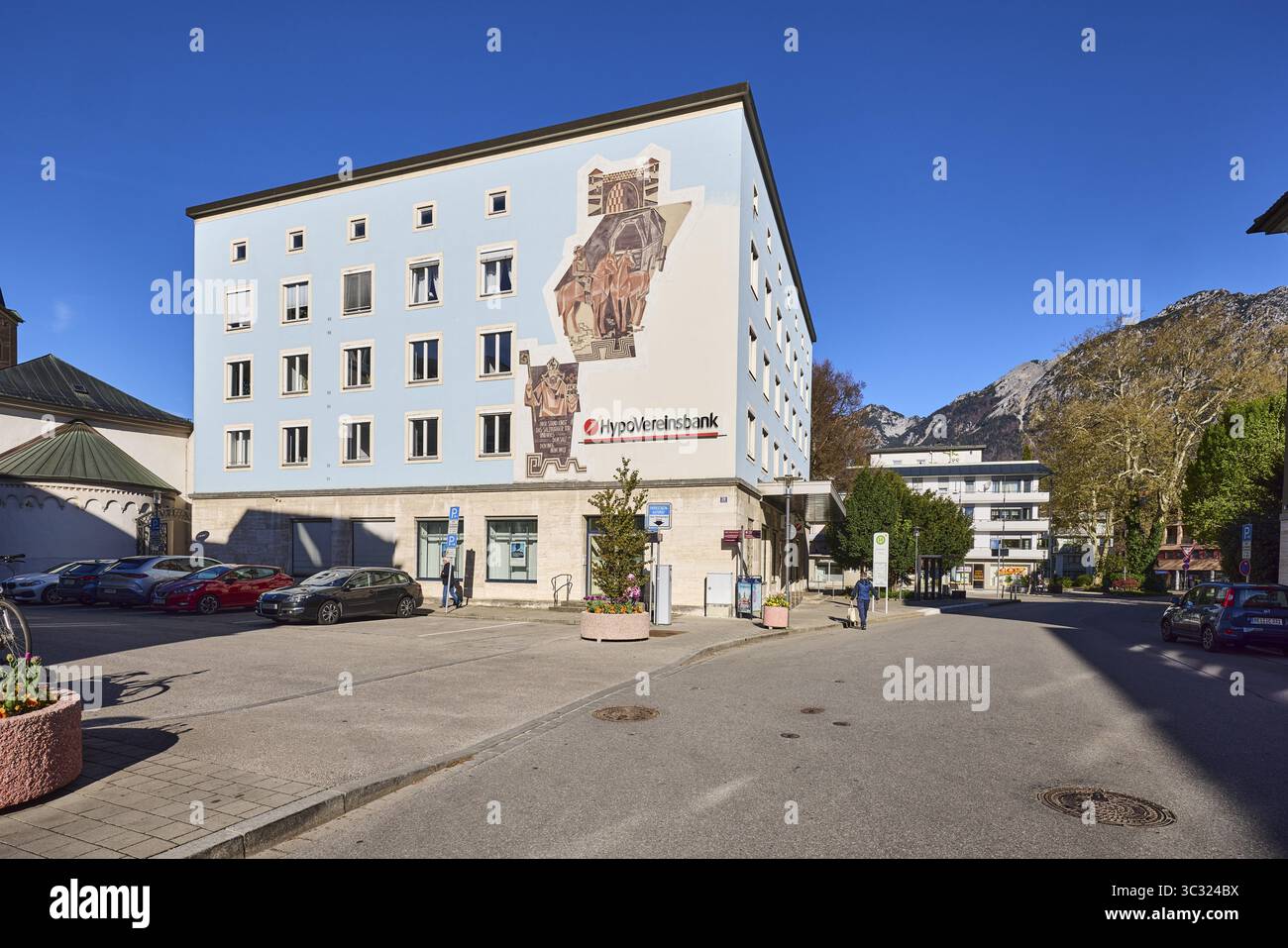 Hypovereinsbank, UniCredit Bank GmbH, edificio residenziale e commerciale, parcheggio, montagne, alberi, cielo blu, senza nuvole, Bahnhofstrasse, Bad Reiche Foto Stock